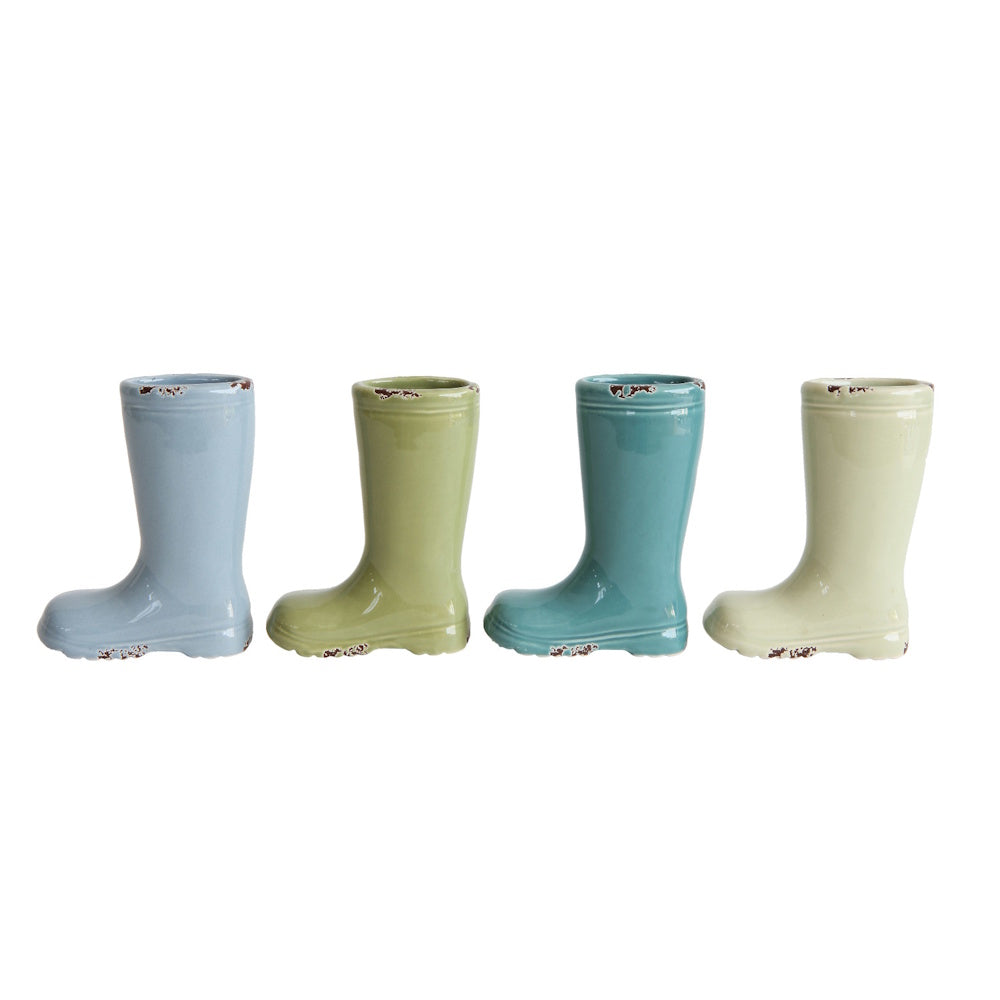 Four ceramic boot-shaped vases in pastel shades of blue, olive green, teal, and sage with distressed details.