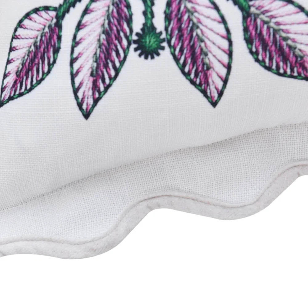 Embroidered leaf pillow with pink and green stitching on white linen fabric featuring a decorative scalloped edge.