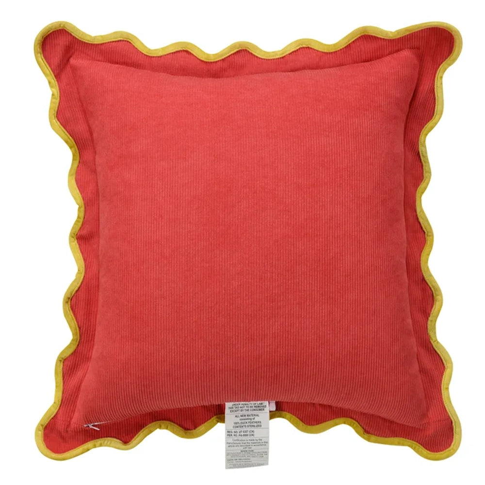 Red corduroy pillow by Tamara Day with yellow scalloped edges and a down-fill law tag on a white background.