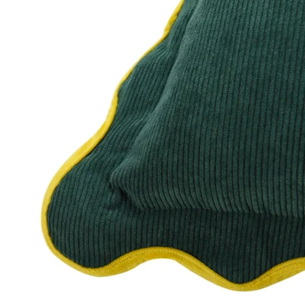 Close-up of a green corduroy scallop-edged pillow with yellow piping by Tamara Day, featuring luxury down-fill texture.