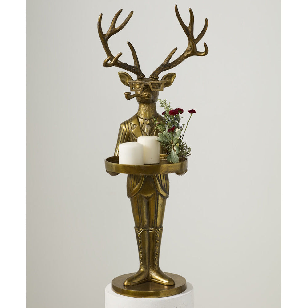 Brass deer butler statue in a suit, holding a tray with two white candles and flowers.