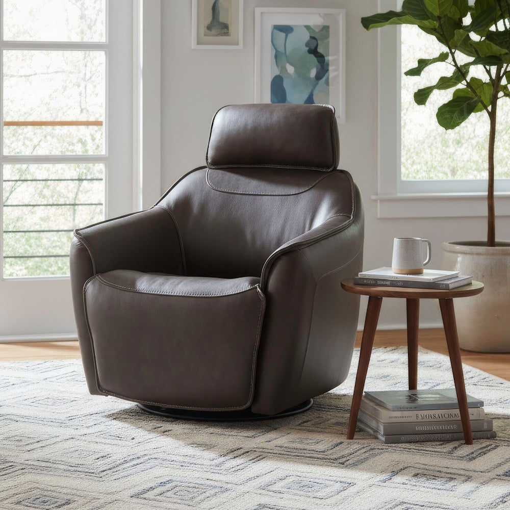 A dark brown leather swivel armchair in a bright living room next to a wooden side table with a mug.