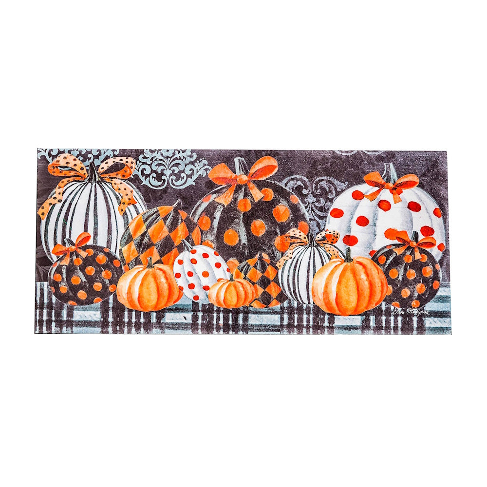 Elegant patterned pumpkins in orange, black, and white with bows on a plaid background for Halloween decor.