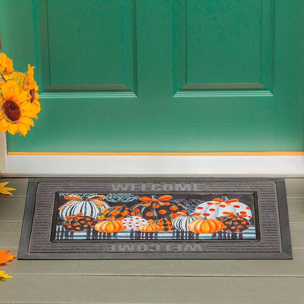 Welcome doormat with elegant patterned pumpkins in front of a green door with sunflowers.