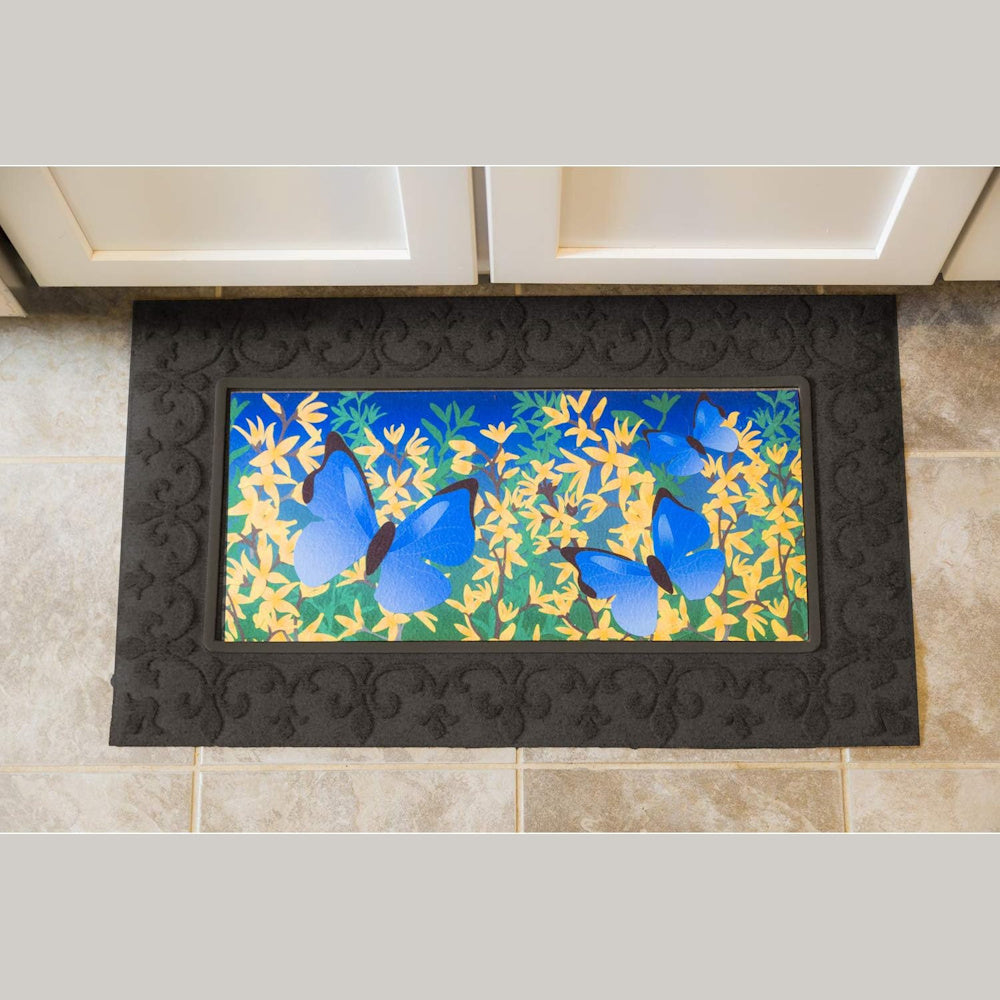 Butterfly doormat with two blue butterflies and yellow flowers, featuring a black scrolled rubber frame and insert.