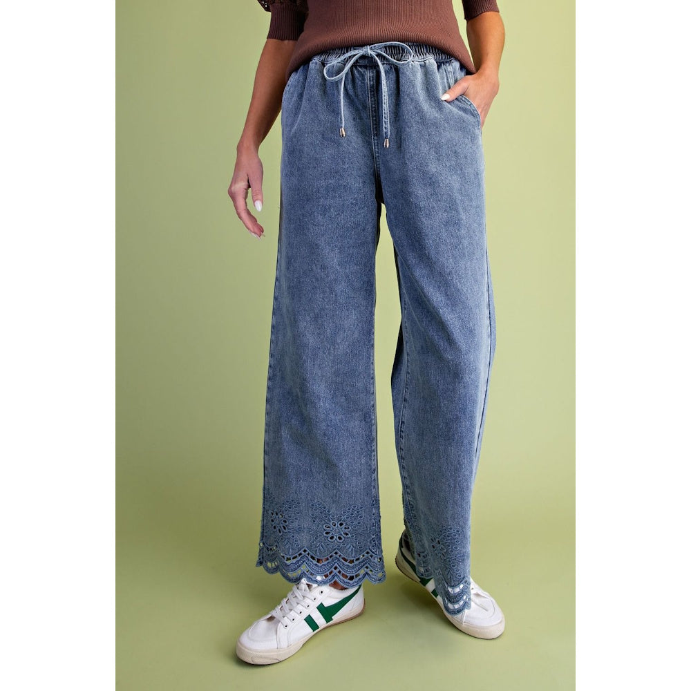 Light blue wide-leg drawstring denim pants featuring eyelet embroidered scalloped hems.