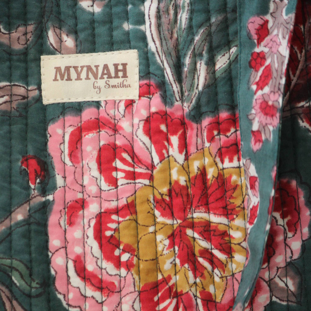 Mynah by Smitha quilted tote bag featuring an emerald forest floral print with pink and yellow flowers and brand label.