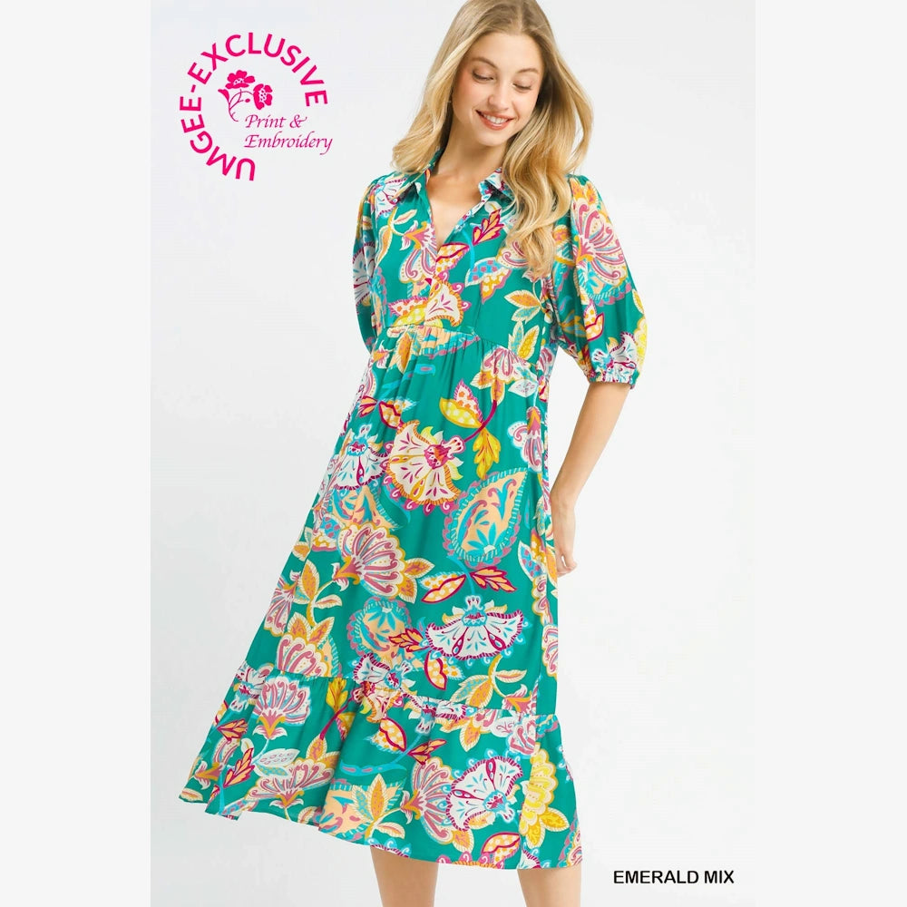 Woman in an emerald mix paisley print maxi dress with a v-neck and puff sleeves against a white background.