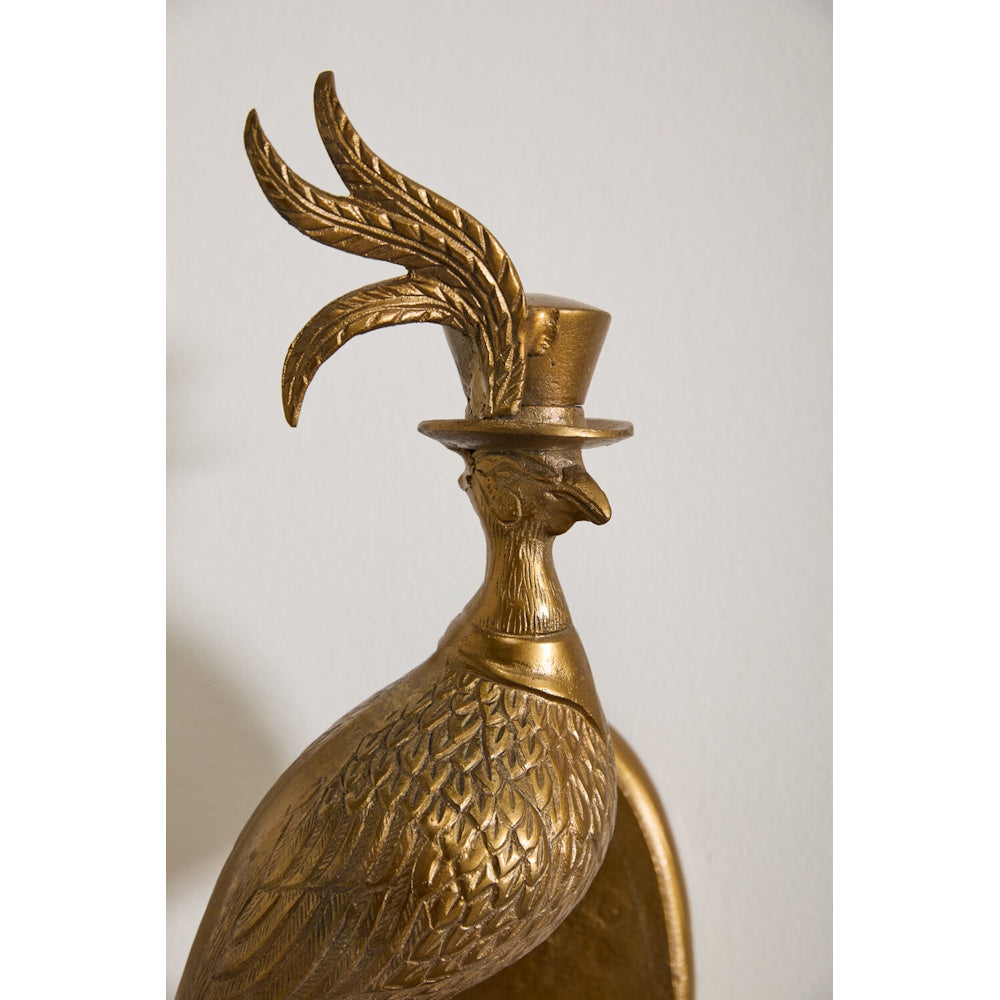 Golden brass bird sculpture wearing a top hat adorned with large feather plumes.
