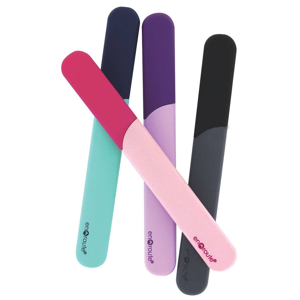 Four En Route glass nail files in pink, purple, turquoise, and grey with matching protective cases on a white background.