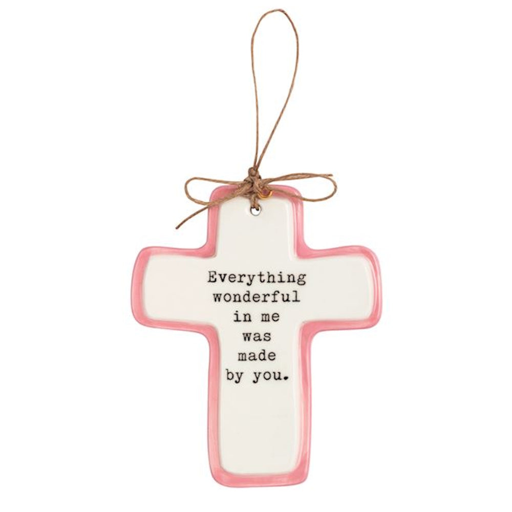 White ceramic cross ornament with pink border and sentimental quote with twine hanging loop.
