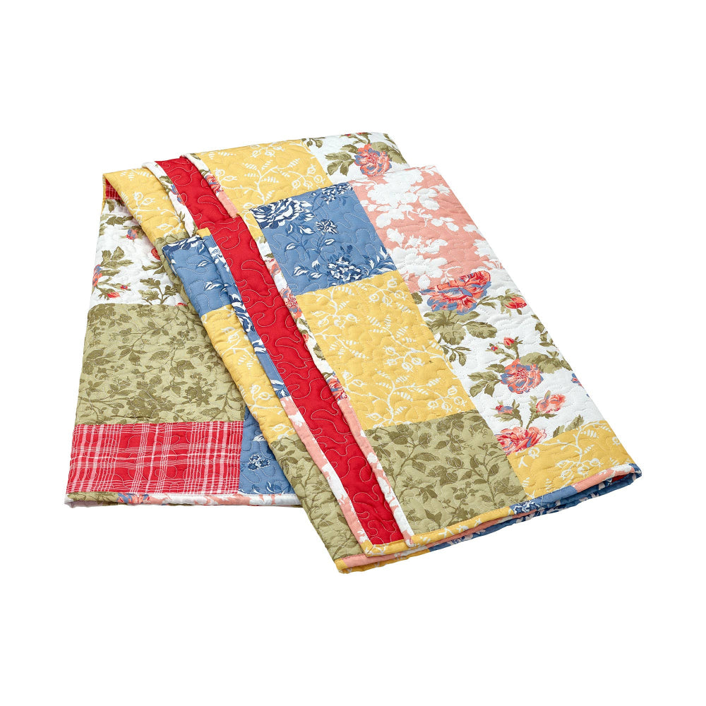 Folded patchwork quilted throw blanket with colorful floral, plaid, and botanical patterns in a farmhouse style.