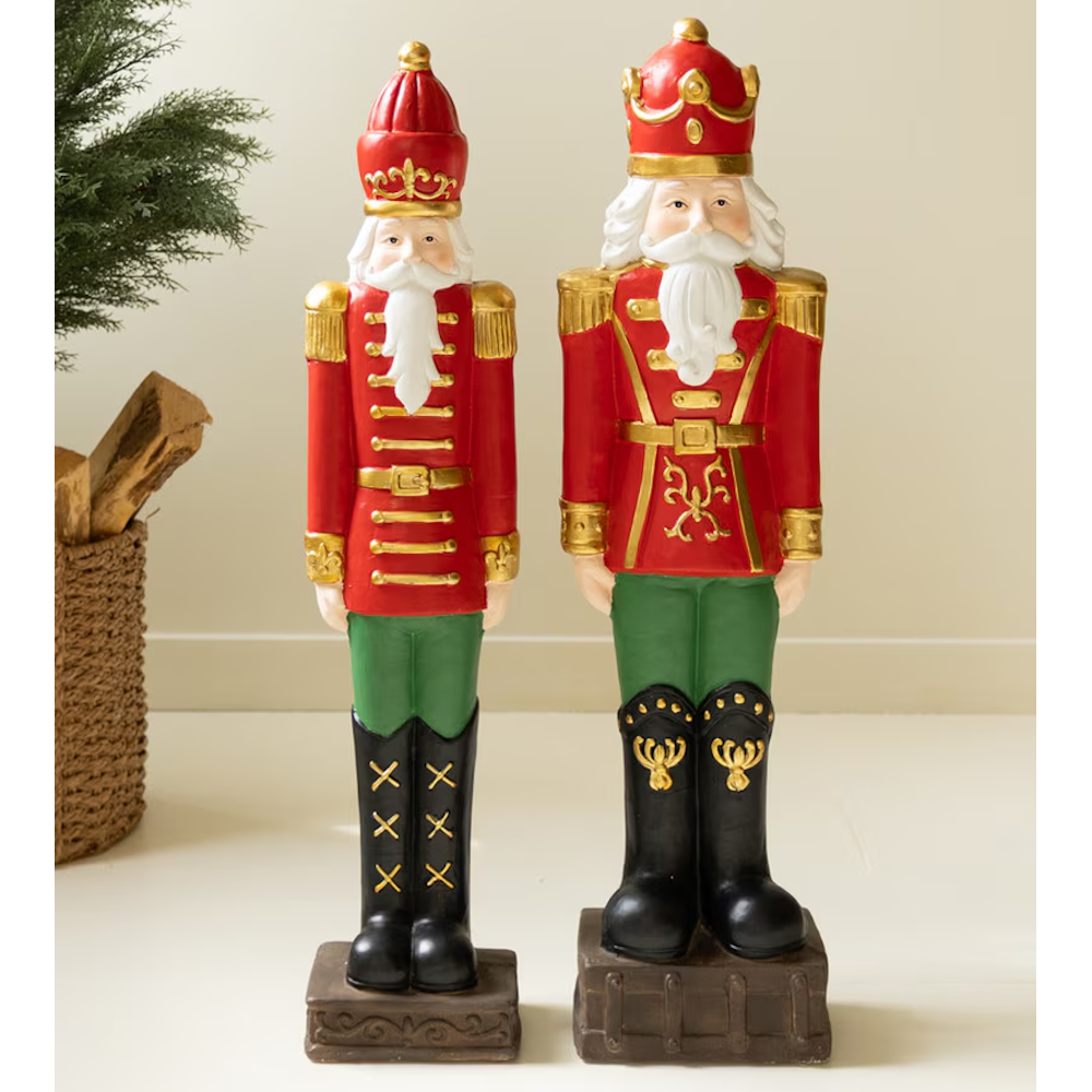 Front view of two faux concrete Christmas nutcracker soldiers in classic red, green, and gold uniform.