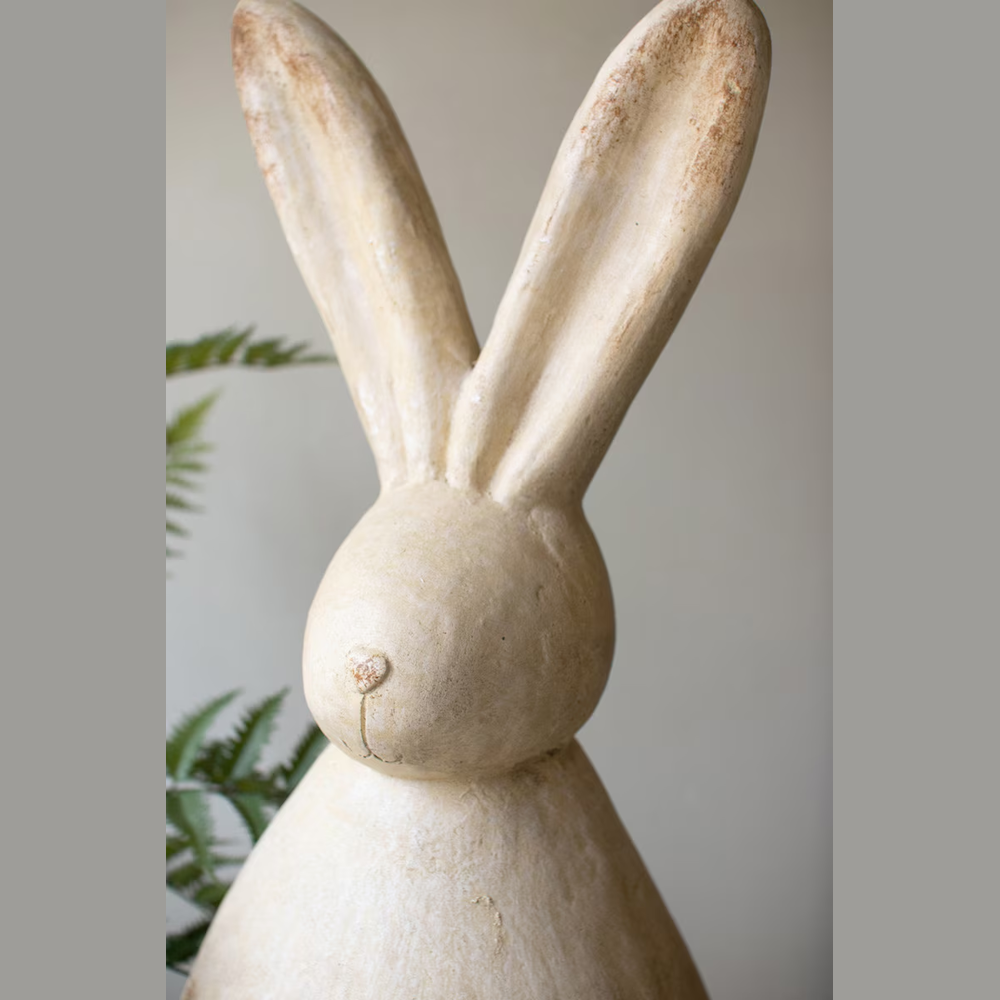Faux stone rabbit sculpture with long ears and a weathered cream finish, perfect for rustic garden or home decor.