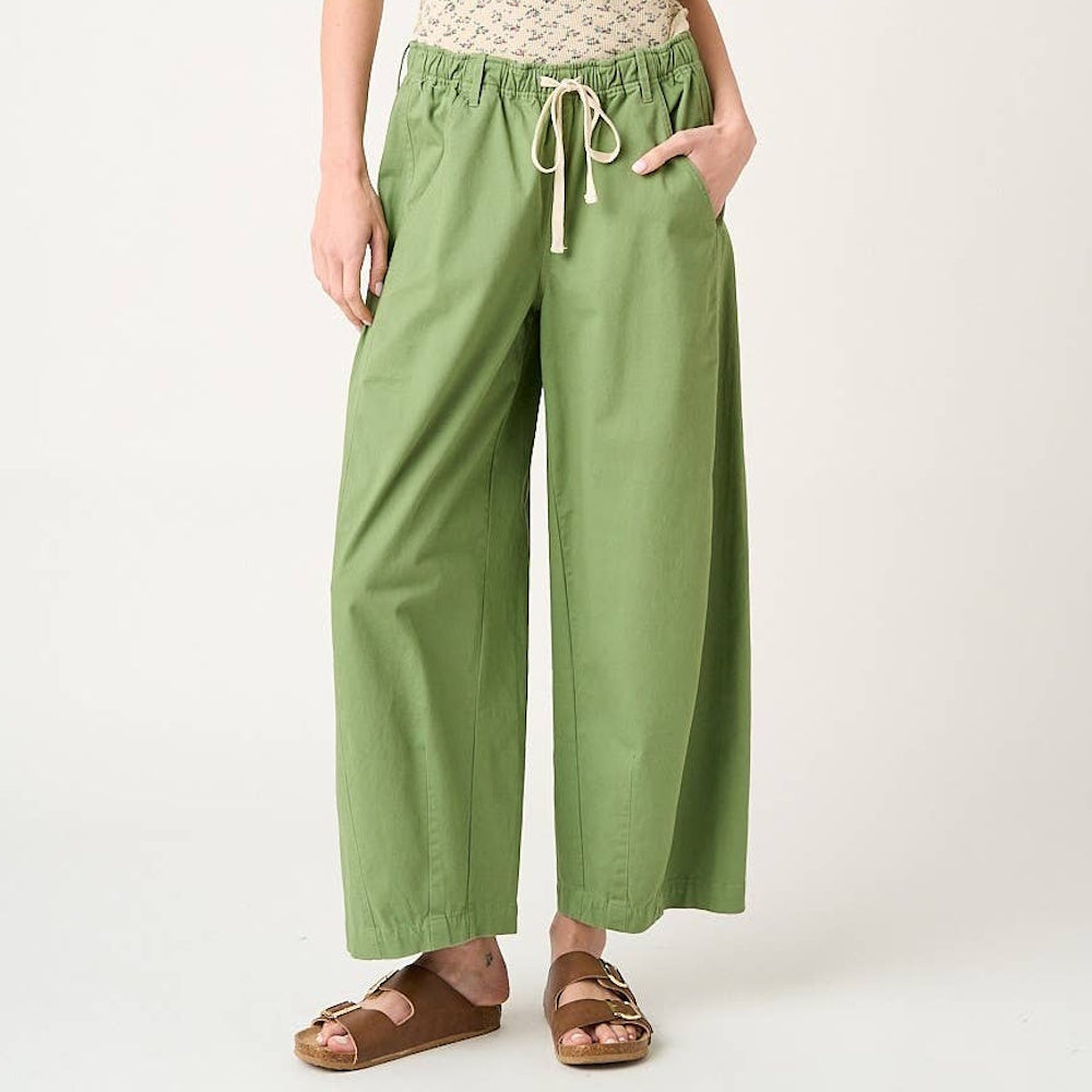Fern green wide barrel leg pants with drawstring elastic waist and pockets, styled with brown slide sandals.