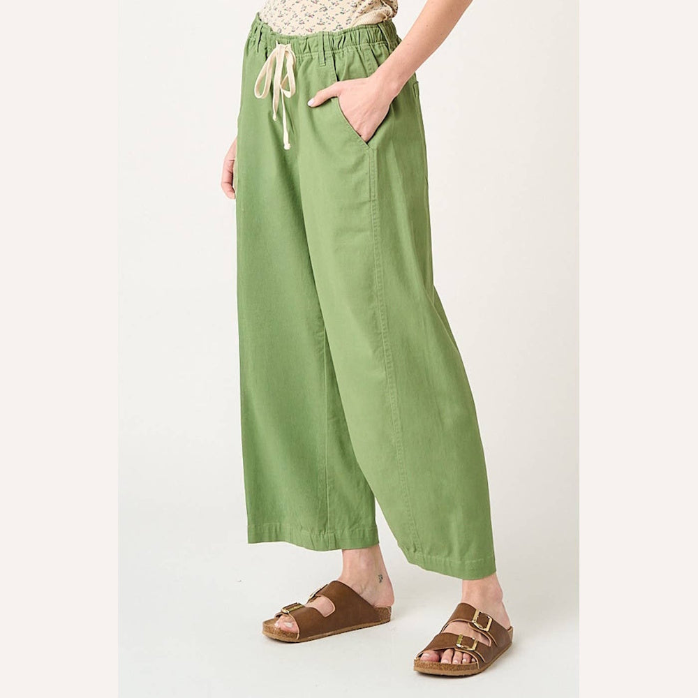 Fern green wide barrel leg pants with drawstring elastic waist and pockets, styled with brown slide sandals.