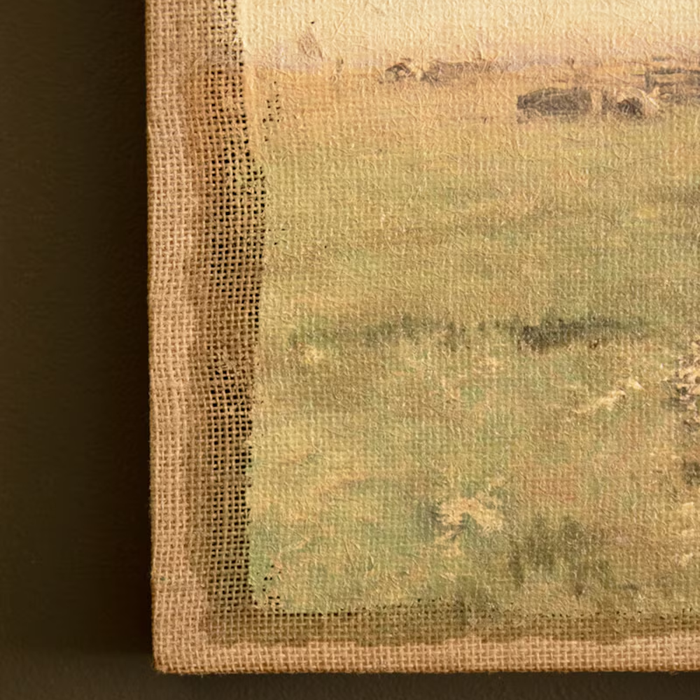 Close-up detail of coarse burlap texture and raw edge on a landscape canvas painting.