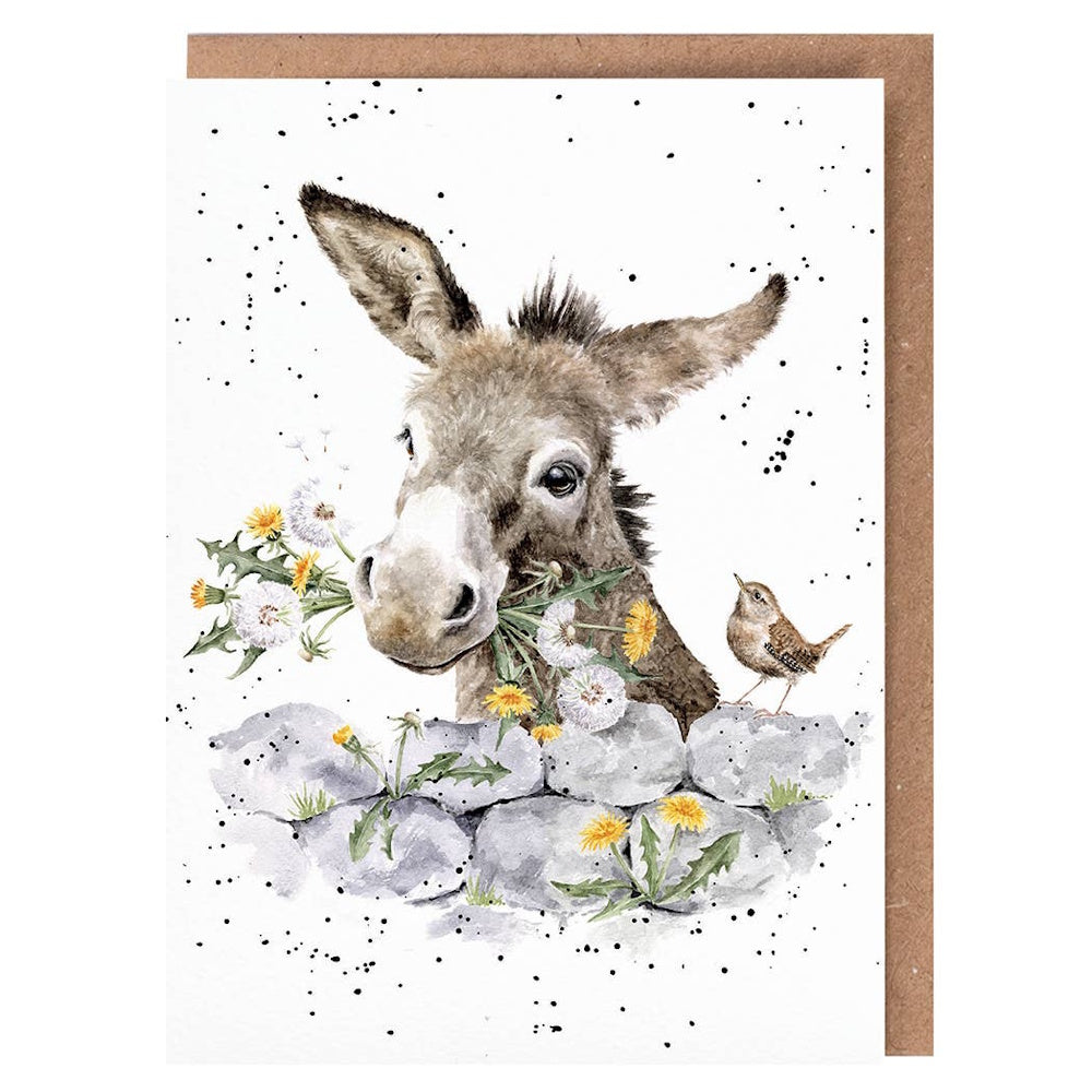 Watercolor illustration of a donkey with dandelions in its mouth, peeking over a stone wall with a small bird.