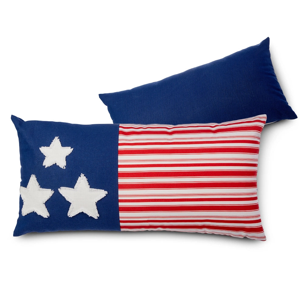Two decorative pillows; one with a design of white stars on a blue field next to red and white stripes, resembling the American flag, and one solid blue pillow.