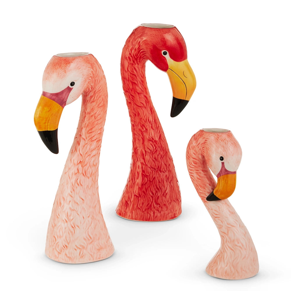 Three ceramic flamingo vases with long necks and orange beaks are displayed. Each vase varies in height, showcasing a whimsical, vibrant design.