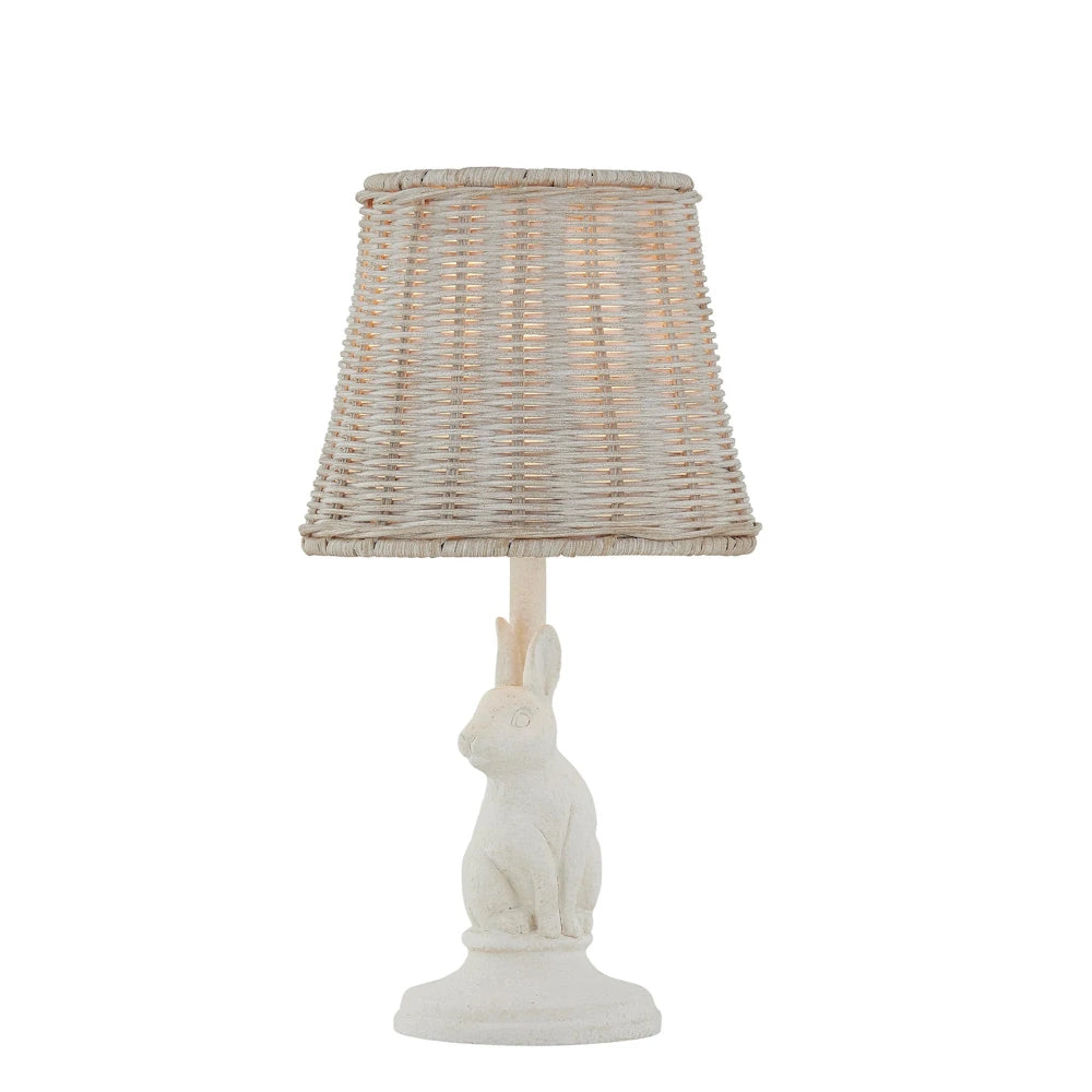 Small white rabbit table lamp with a woven wicker shade on a white background.