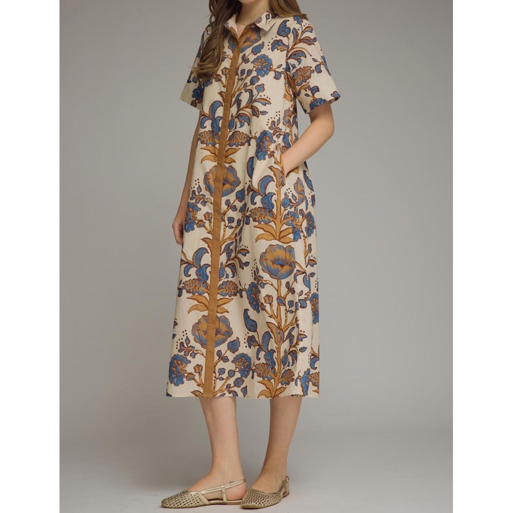 Three-quarter side view of a beige floral batik midi shirt dress with side pockets, short sleeves, and placket detail.