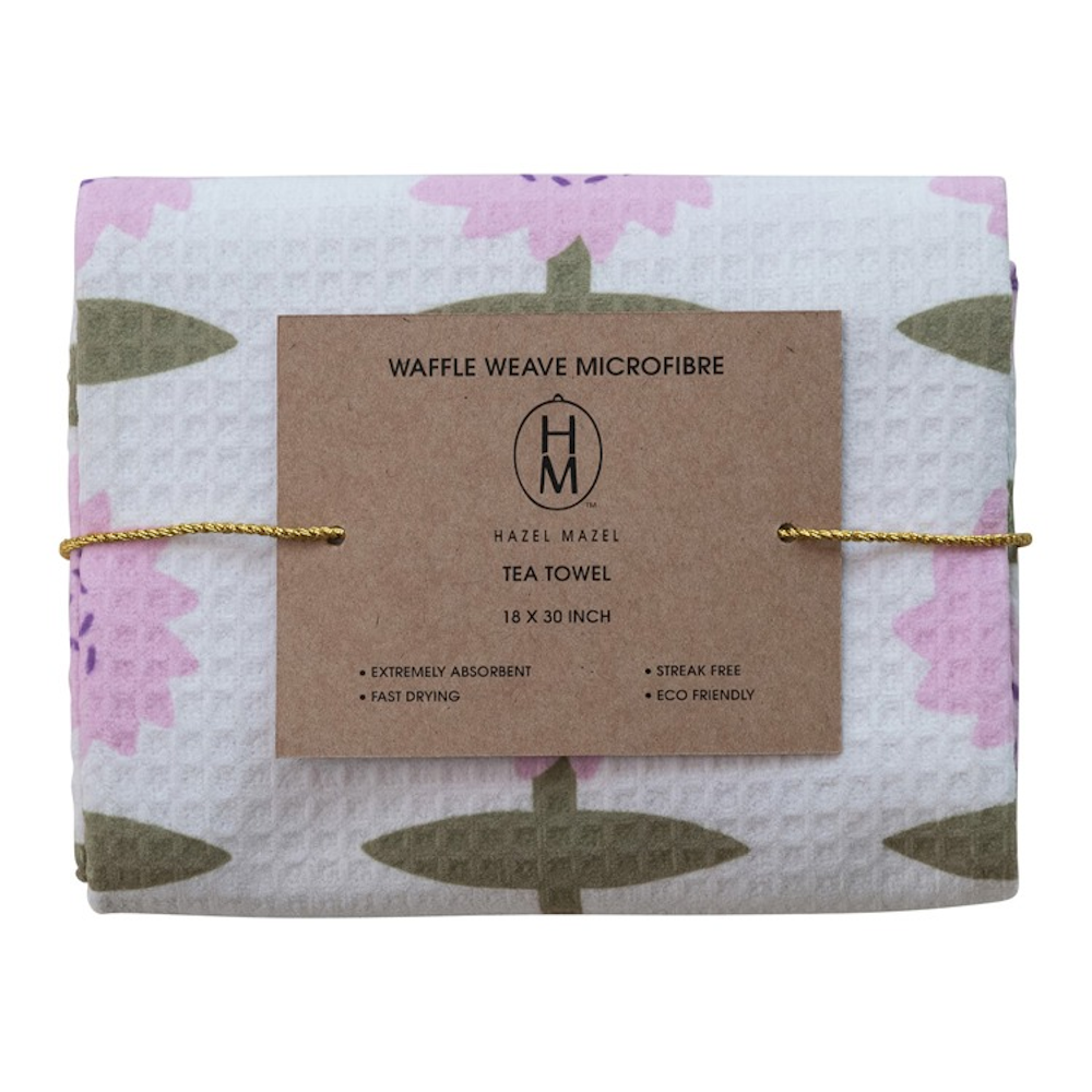 Folded waffle weave tea towel with a pink floral print and brown product label.