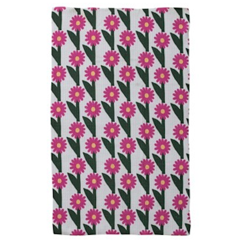 Flat tea towel featuring a repeating pattern of magenta flowers with yellow centers and green leaves.