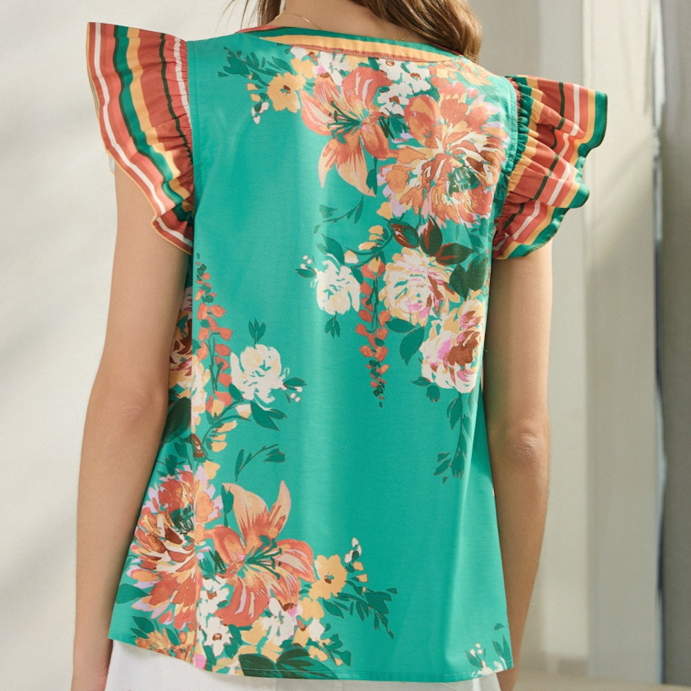 Back view of a green floral blouse with orange and white flowers and striped ruffle sleeves.