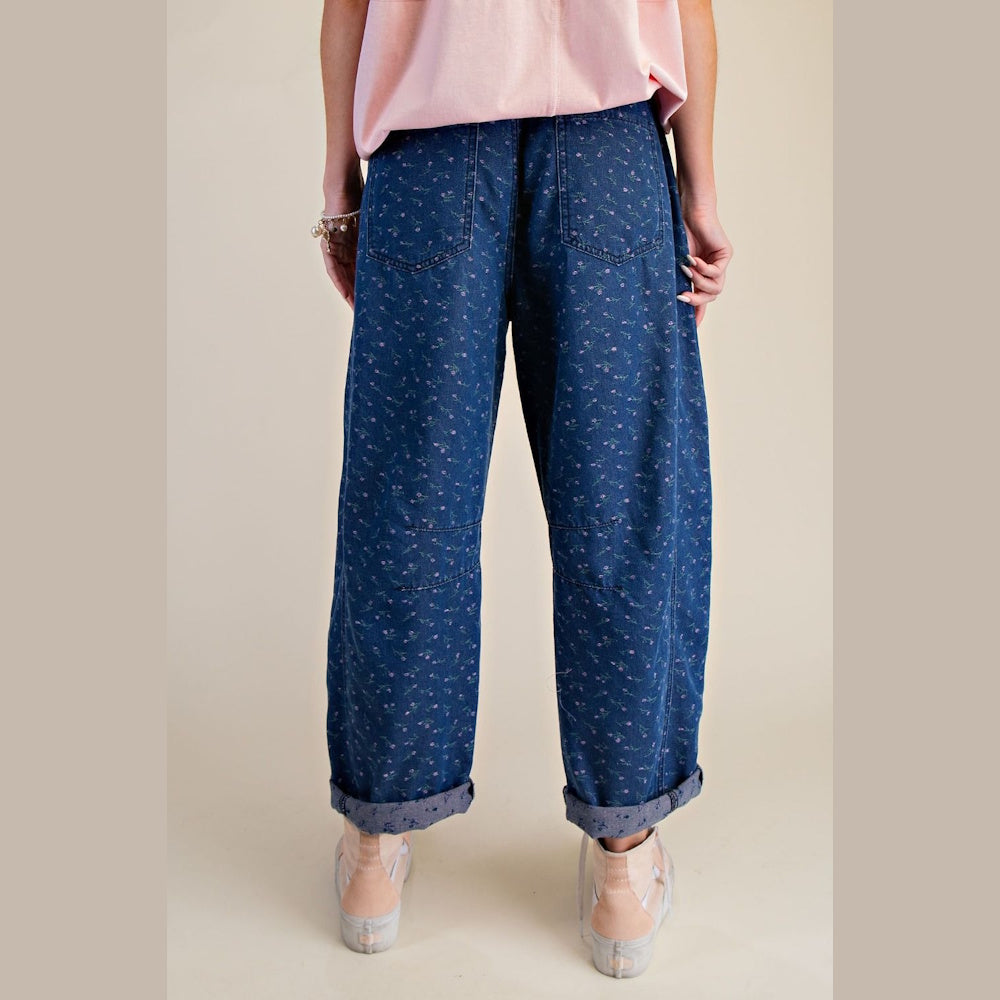 Back view of blue floral print barrel jeans with a washed finish, relaxed fit, and cuffed hems.