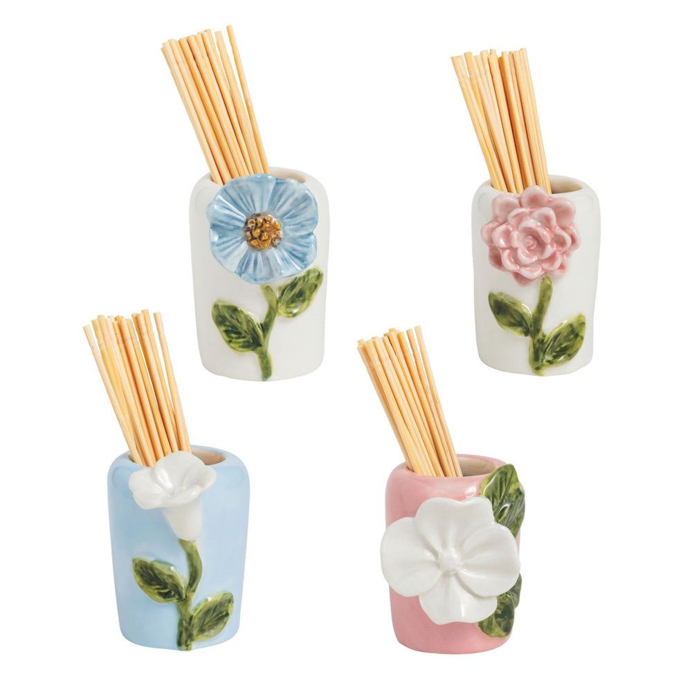 Four small ceramic toothpick holders in white, light blue, and pink, each adorned with a unique 3D sculpted flower.