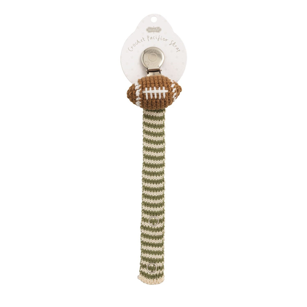 Crochet football pacifier clip with green and white striped strap and metal clip on a white background.