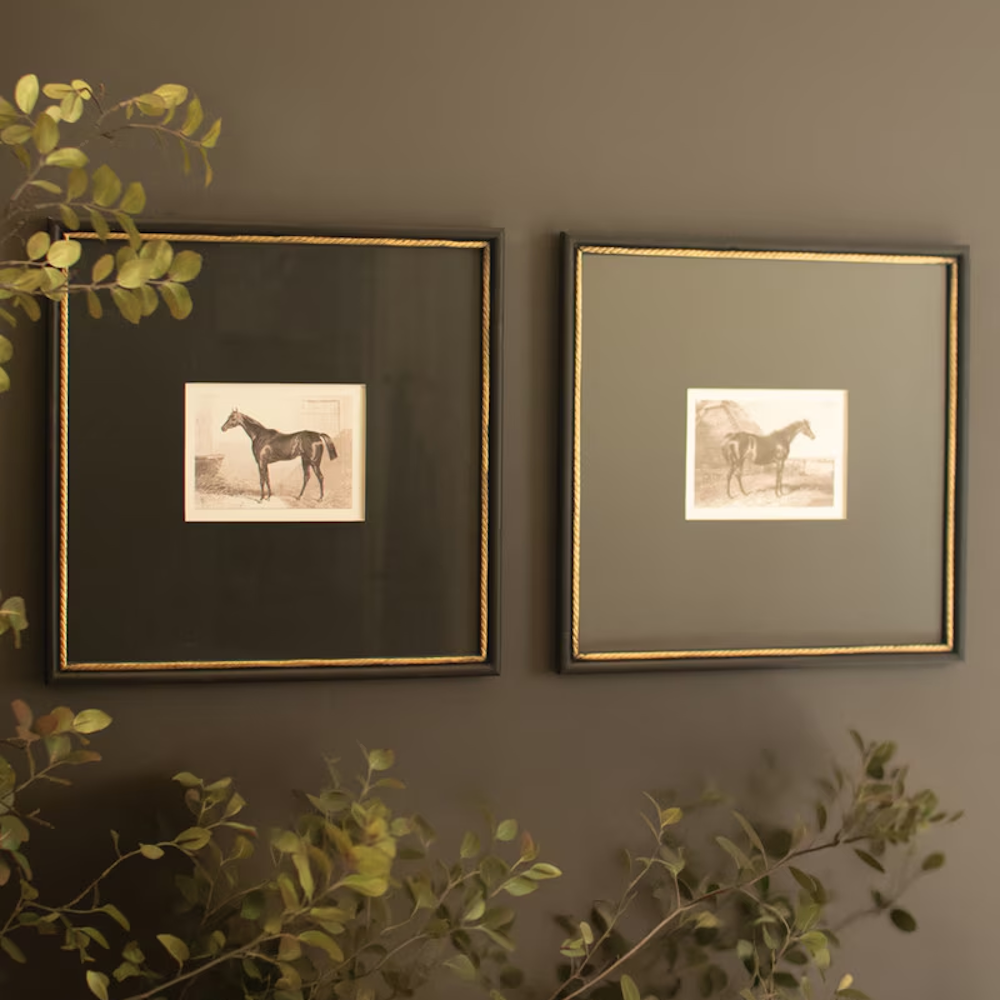 Set of two black and white equestrian horse prints in dark frames with gold trim under glass.