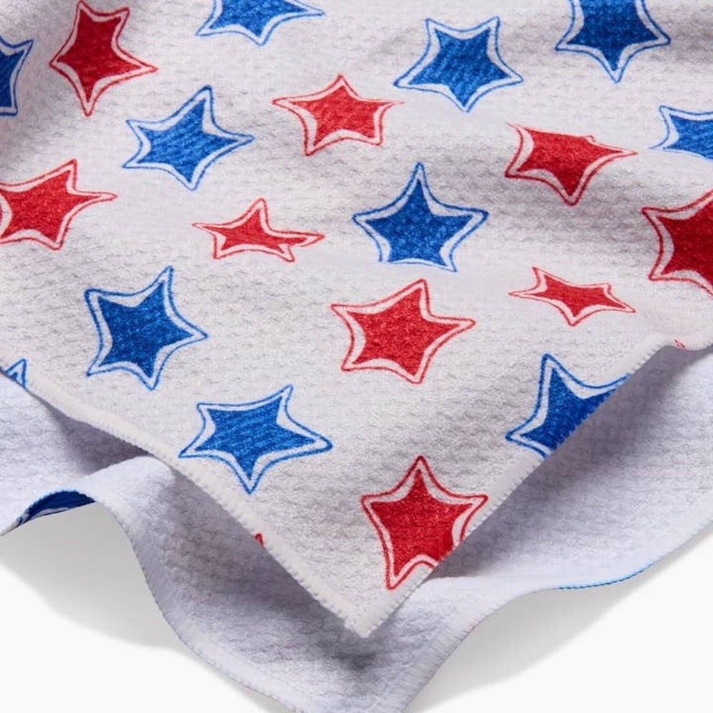 Red and blue hand-drawn stars scattered on a white, textured tea towel with a soft, draped edge.