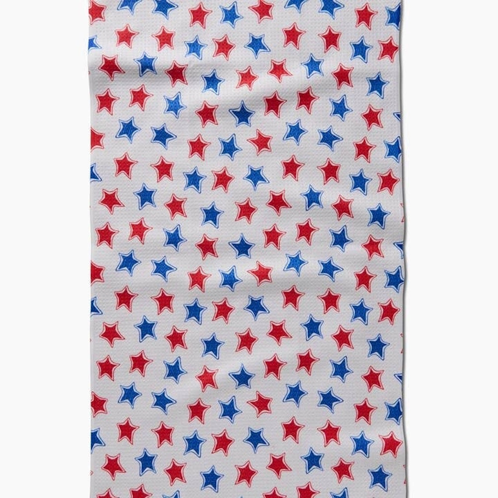 A pattern of red and blue hand-drawn style stars scattered across a white textured fabric background.