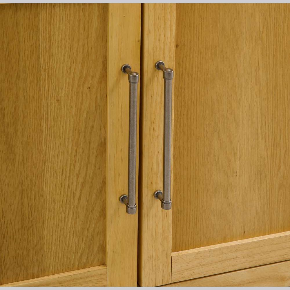 Close-up of light oak wood cabinet doors with rustic brushed metal bar handles.