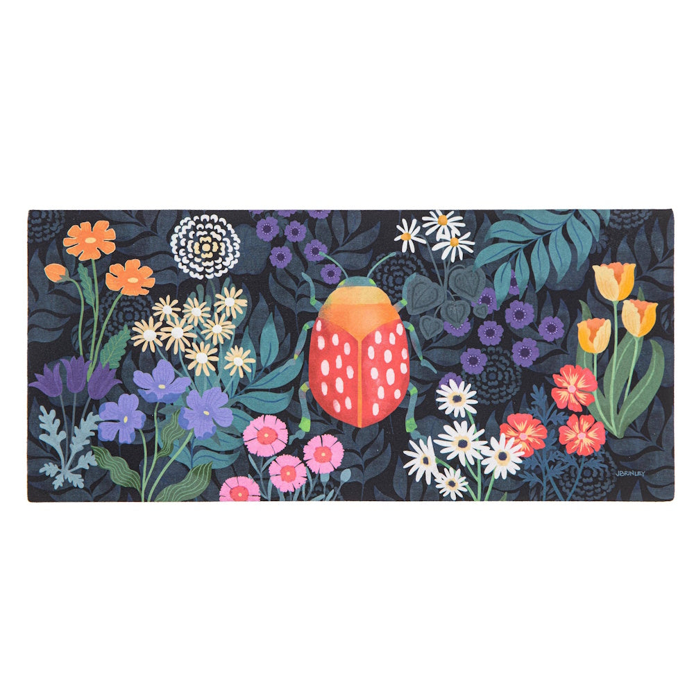 Colorful illustration of a red spotted beetle surrounded by whimsical flowers and dark foliage on a rectangular mat.