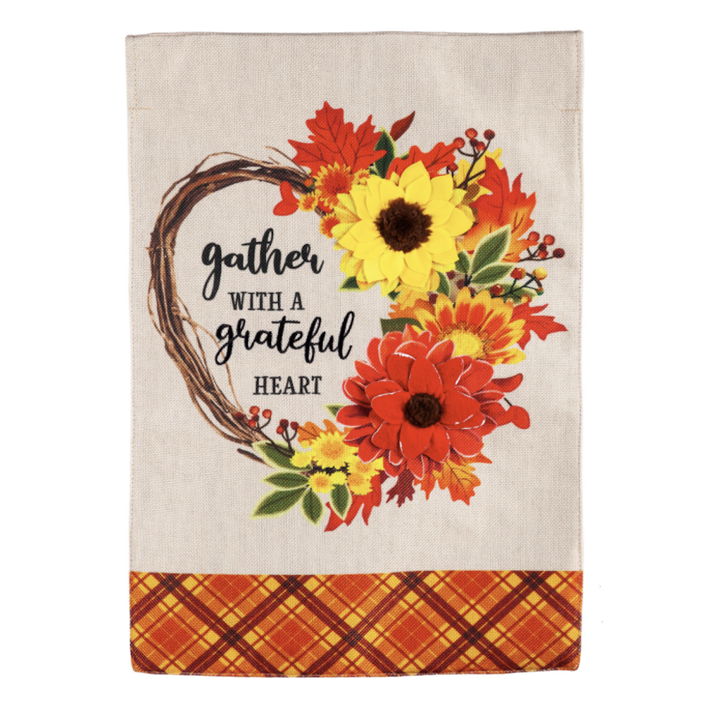 Burlap flag with a heart floral wreath reading 'gather with a grateful heart' and orange plaid border.