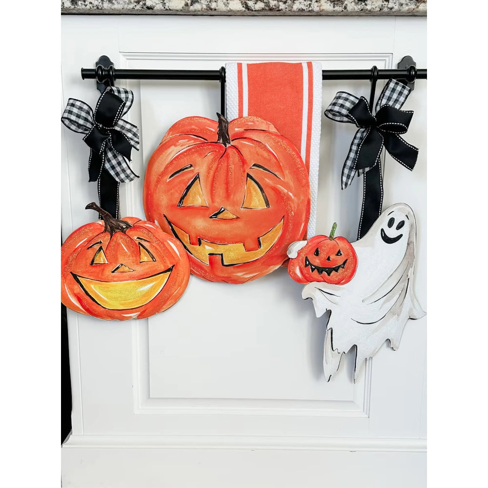 Halloween pumpkin and friendly ghost hanging decorations with black and white gingham bows.
