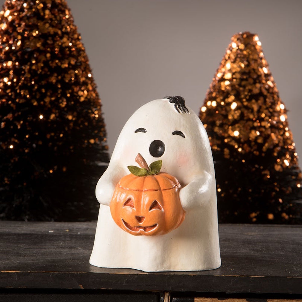 Small white ghost figurine holding a jack-o'-lantern pumpkin, with a spider on its head.