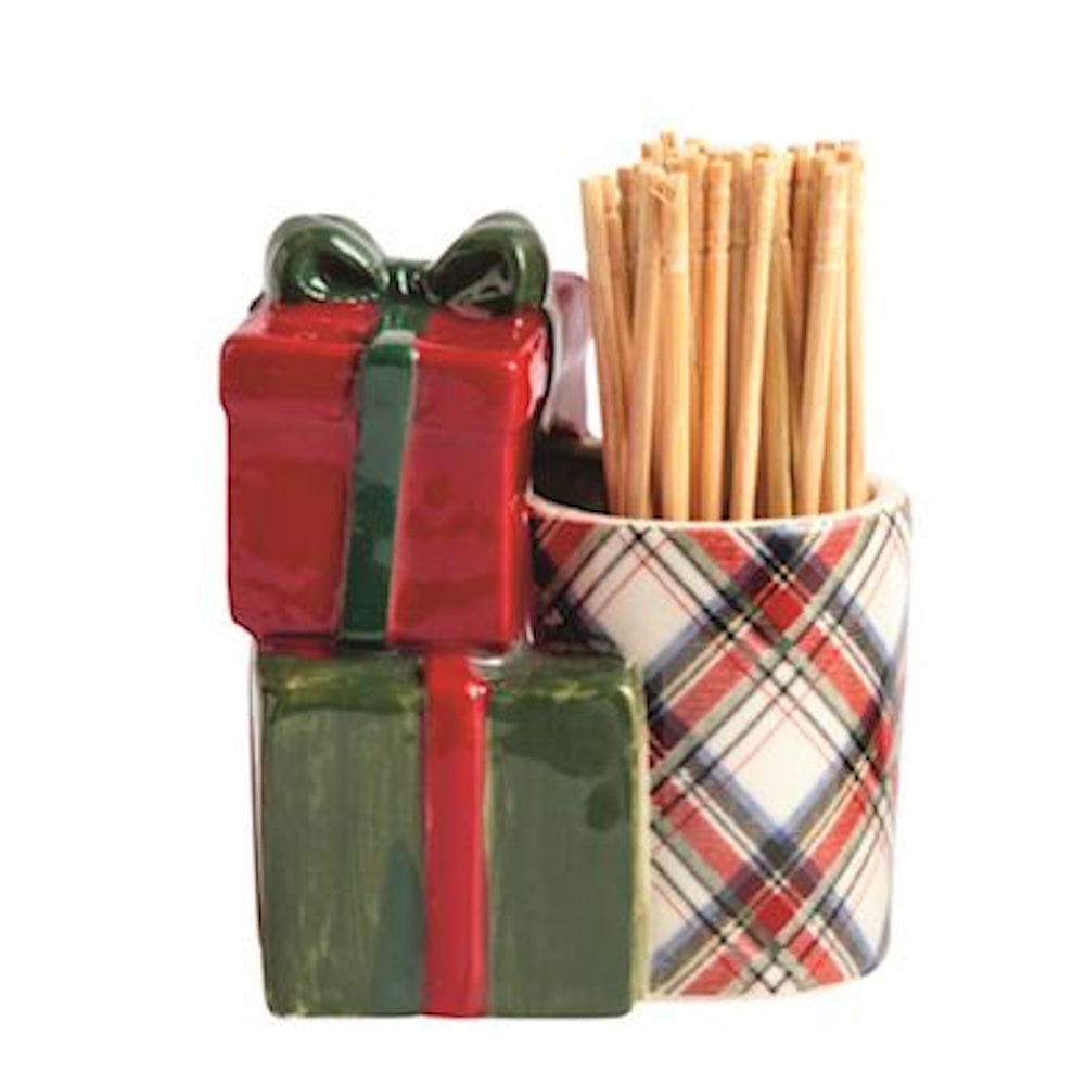 Ceramic stacked Christmas presents figurine alongside a white plaid caddy holding wooden toothpicks.