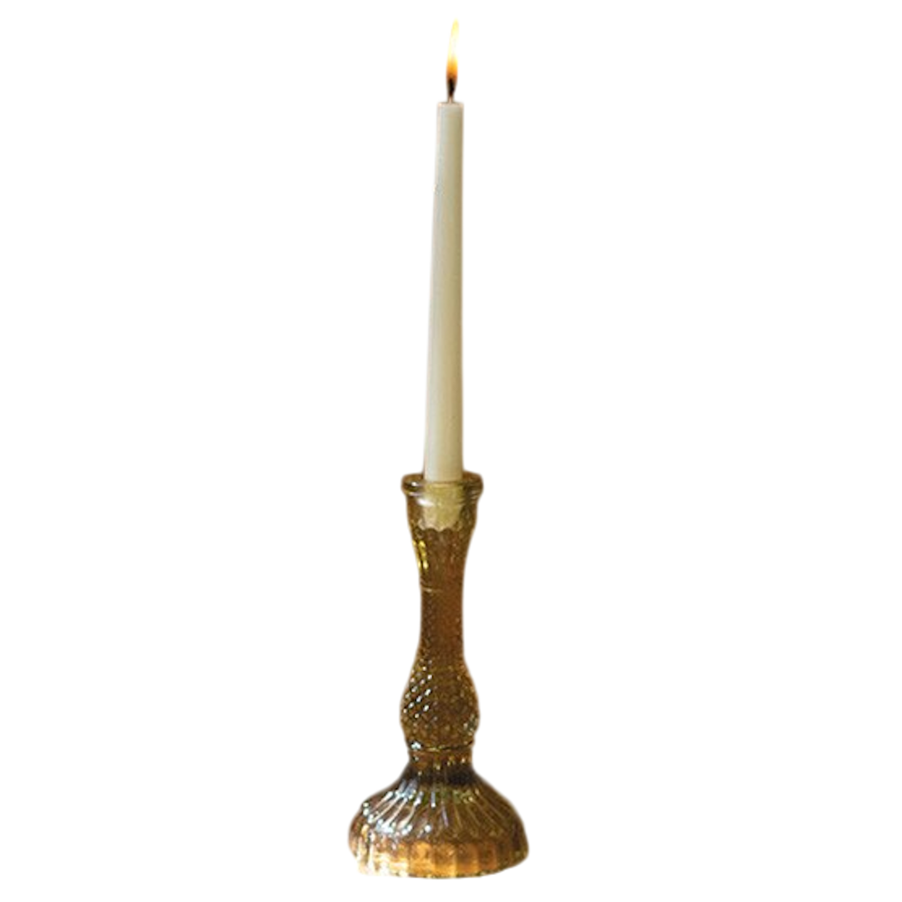 Amber vintage-style embossed glass taper candle holder with a lit white candle on a white background.