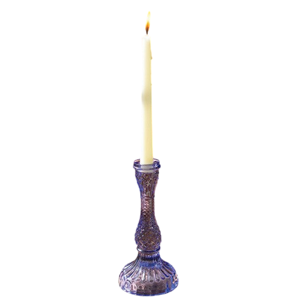 A single lavender purple textured glass taper candlestick holder with a lit cream-colored candle on a white background.