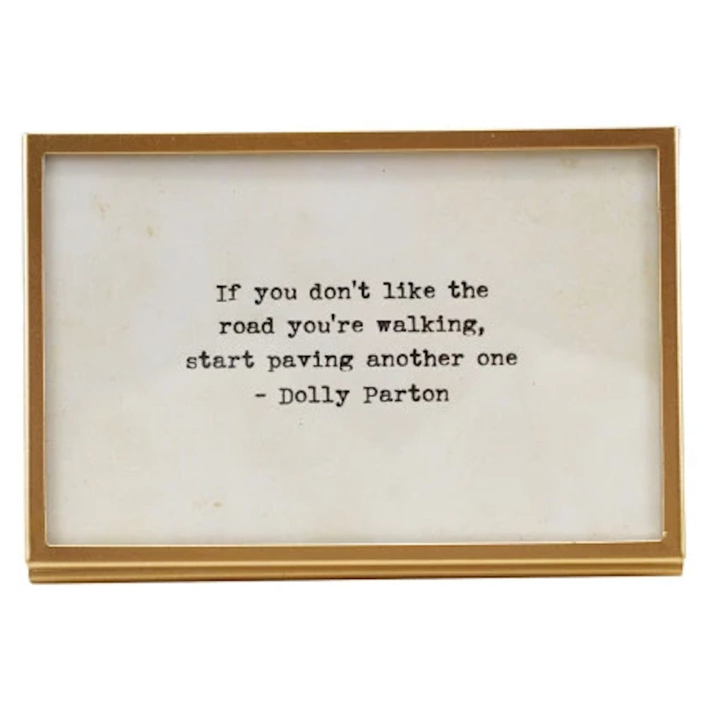 Gold metal and glass frame featuring an inspirational Dolly Parton quote about paving your own road.