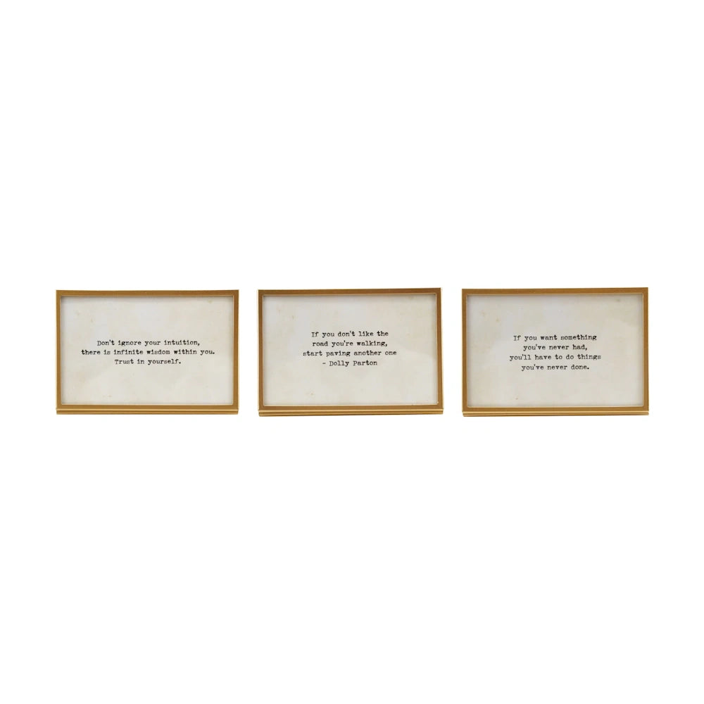 Set of three gold metal and glass frames with typewriter-style inspirational quotes and easel stands on a white background.