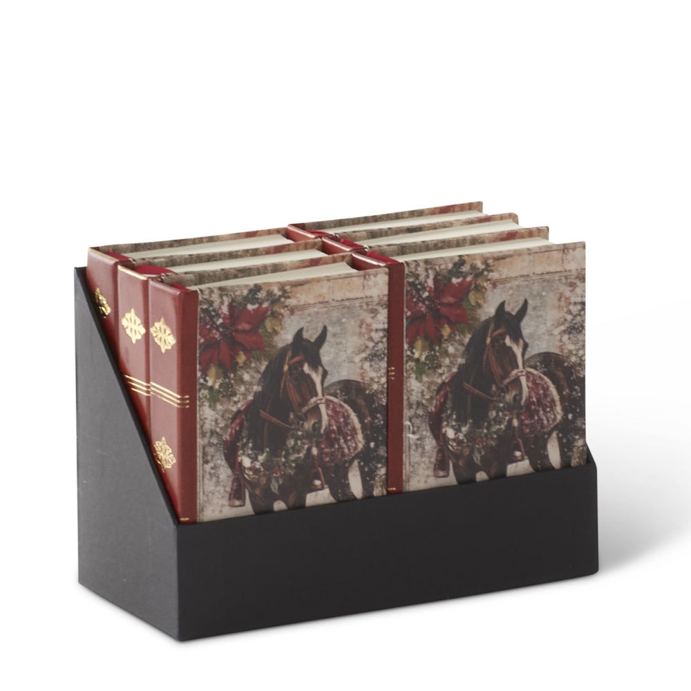 A display holder containing several equestrian Christmas journals with red spines.