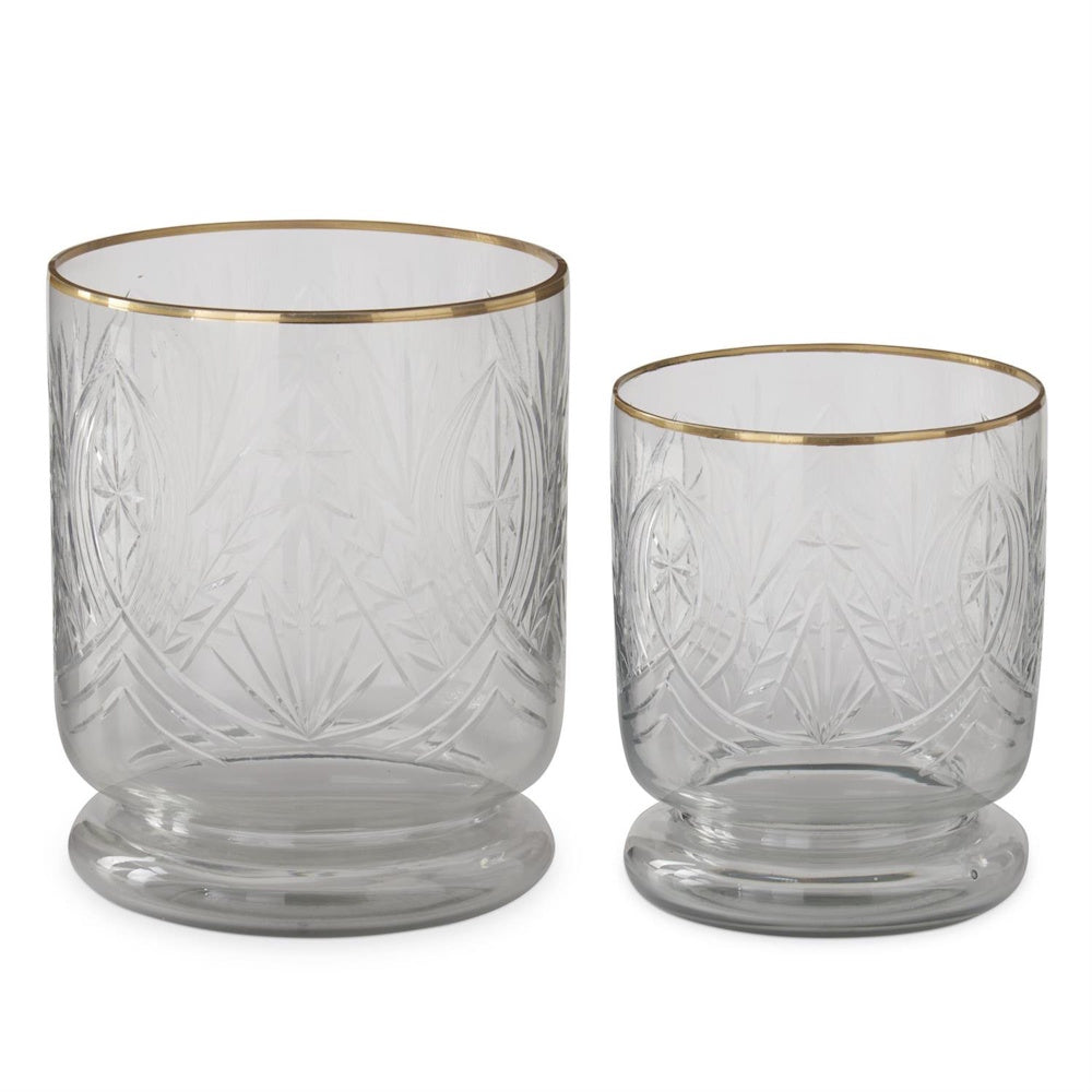 Two gold-rimmed cut glass containers in varying sizes with intricate etched patterns and pedestal bases.
