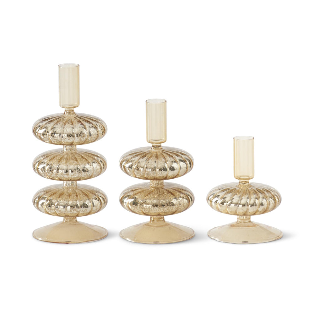 Set of three gold mercury glass taper candleholders with ribbed, stacked bulbous sections on a white background.