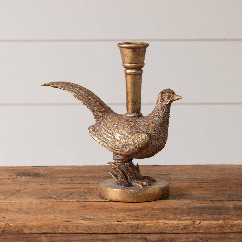 A gold-tone pheasant candleholder featuring a bird figure standing on a round base with a candle cup on its back.