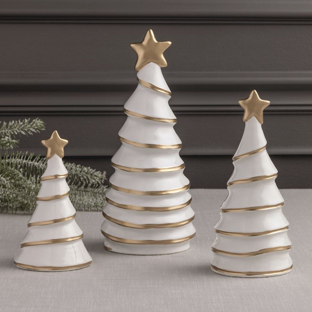 Set of three white ceramic Christmas tree figurines with spiral gold trim and gold star toppers.
